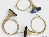 trois instruments de musique en laiton disposés en cercle sur une surface blanche