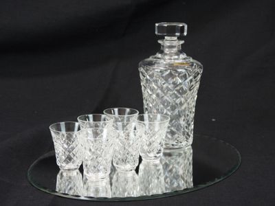 a glass tray with a glass decanter and four glasses on it