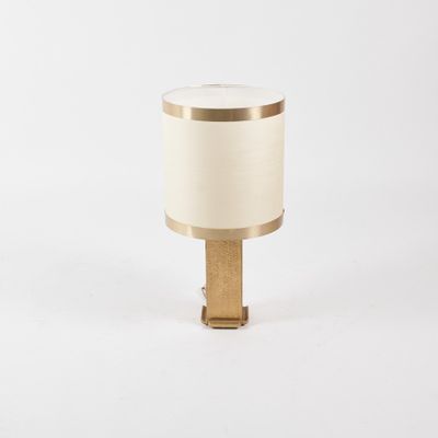 une lampe de table blanche et dorée avec un pied en bois