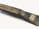 un vieux couteau au manche en bois posé sur une surface blanche