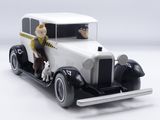 a figurine of a man and a dog riding in a car