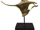 une photo d'une statue en bronze représentant une raie manta posée sur un socle noir