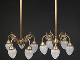 a pair of antique brass and frosted glass chandeliers