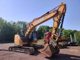 a yellow and black excavator sitting in a parking lot
