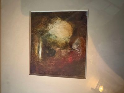 une photo d'un tableau accroché au mur au-dessus d'un lit