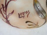 a close up of a vase with a bird on it