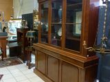 a display case in the middle of a room filled with antiques
