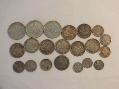 several coins are arranged on a white surface with a white background