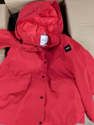 La veste est rouge et comporte une capuche qui en fait partie intégrante.