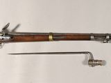 un vieux pistolet avec un canon en bois et une poignée en métal