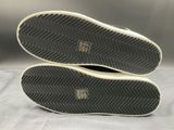 the soles of a pair of black and white sneakers