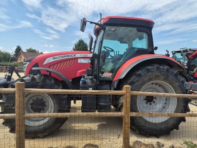 un tracteur rouge garé derrière une clôture