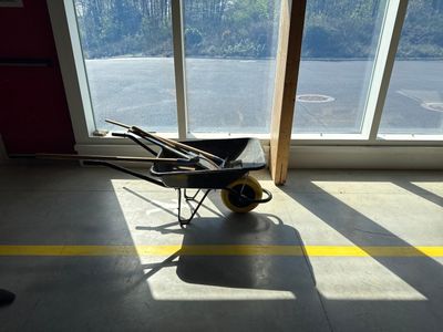 a wheelbarrow in the middle of a room with a lot of windows