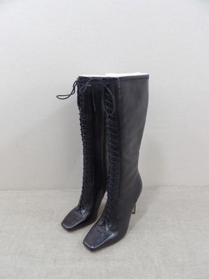 a pair of black boots sitting on top of a white floor