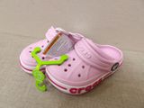 a pink crocs shoe with a green frog on it