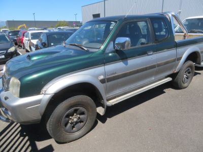 une photo d'un pick-up vert garé sur un parking