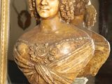 a bust of a woman sitting on a shelf in front of a mirror