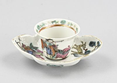 une petite tasse et une soucoupe décorées d'un motif