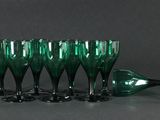 quatre verres à vin verts posés les uns à côté des autres sur une table