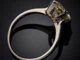 a close up of a yellow diamond ring on a black surface