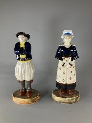 pair of ceramic figurines of a man and a woman in traditional clothing