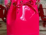 sac seau rose fluo avec poignée en forme de nœud et bandoulière à chaîne