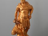 a gold statue of a man holding a dog on a chain