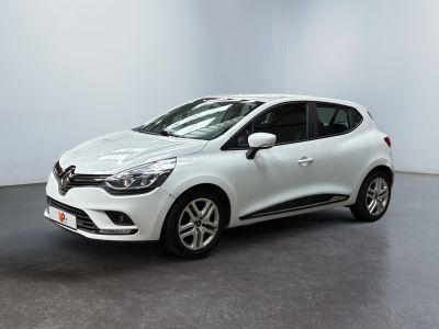 une voiture blanche garée dans une pièce blanche au sol noir