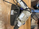 une photo d'une perceuse filaire posée sur une table en bois