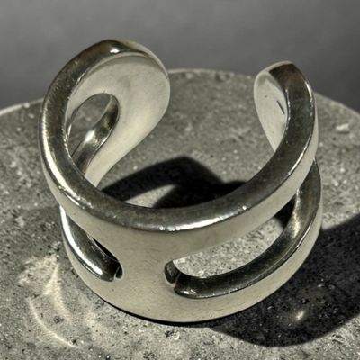 bague en argent massif présentant un motif incurvé sur un galet