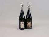 two bottles of wine sitting next to each other on a white surface