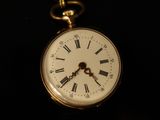 a gold pocket watch with roman numerals on it