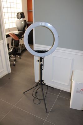 une photo d'une pièce avec un miroir et une lampe posée sur un trépied