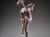an image of a bronze statue of a woman holding a tennis racquet