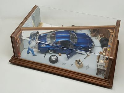 a model of a blue car in a glass case