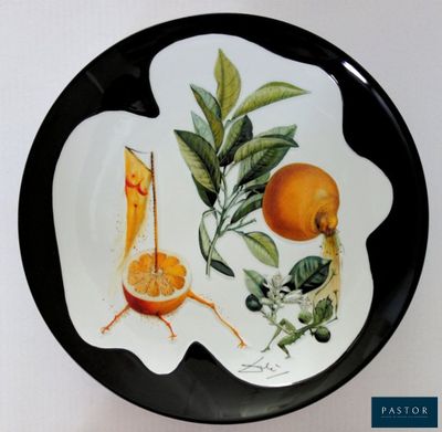 une assiette en noir et blanc sur laquelle sont disposées des oranges et des feuilles