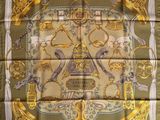 a square scarf with a gold and green design on it