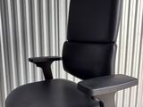 an office chair with black leather upholstered seat and foot rest