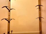 a mirror hanging on the wall above a shelf with hooks
