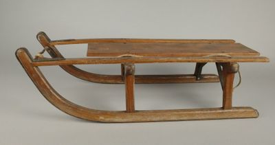une vieille luge en bois surmontée d'une autre luge