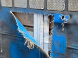 a skateboard stuck in the side of a blue truck