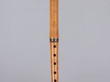 a close up of a wooden flute on a clear surface