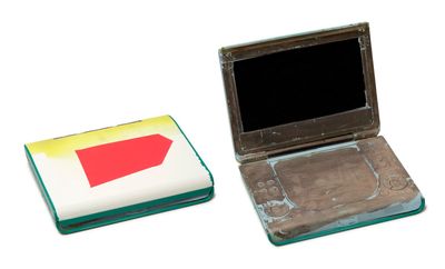 a small laptop computer sitting next to a smaller laptop computer