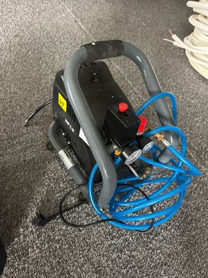 un tuyau bleu raccordé à un compresseur d'air gris et noir