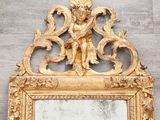 a mirror with a gold frame on a wall