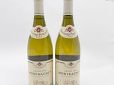 deux bouteilles de vin blanc posées l'une à côté de l'autre sur une surface blanche