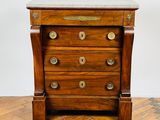 une vieille commode en bois avec un plateau en marbre, posée sur un sol en caillebotis