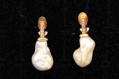 une paire de boucles d'oreilles en perles et diamants sur fond de velours noir