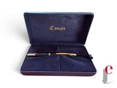 une boîte contenant un stylo, posée sur une surface blanche