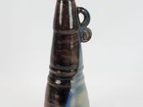 a brown and blue vase sitting on a white surface